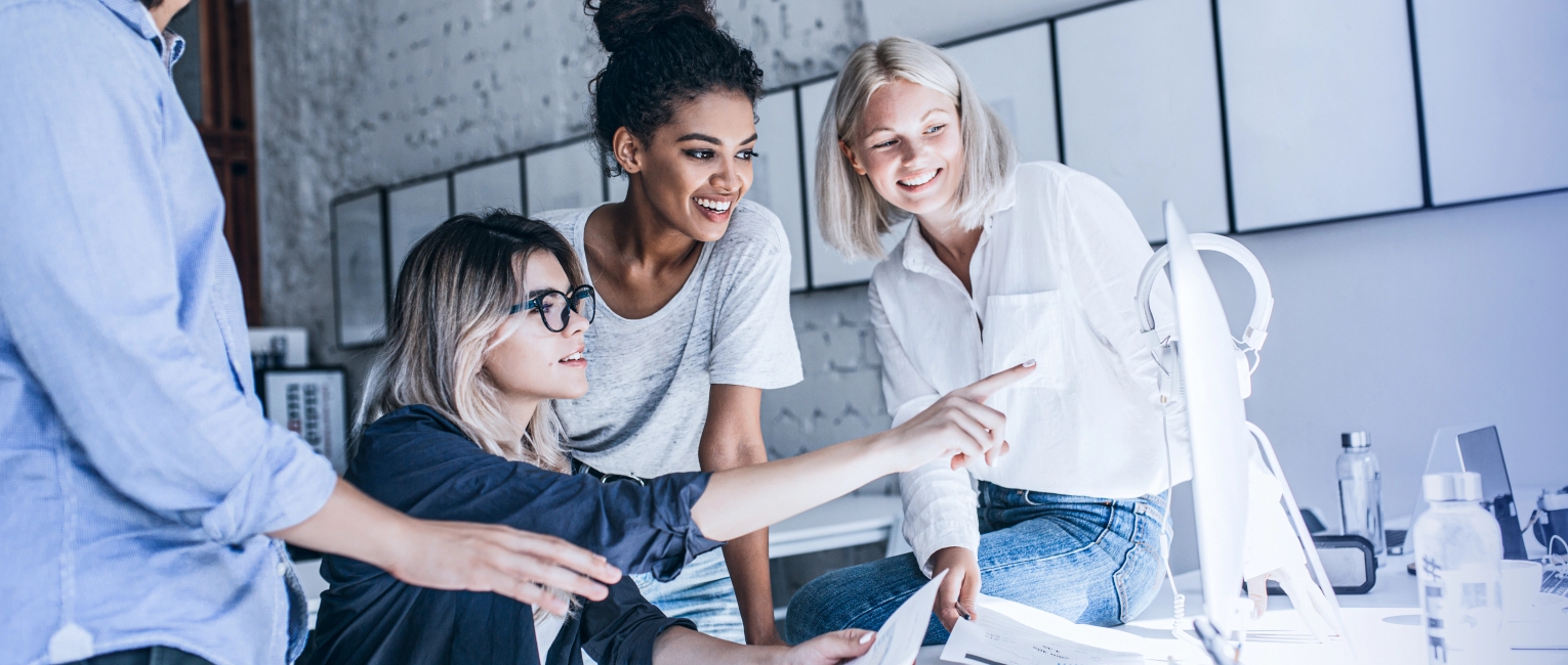 Drei Frauen im Team besprechen und lachen